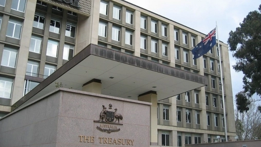 Front entrance of The Treasury in Canberra with the Australian coat of arms sign and a national flag above